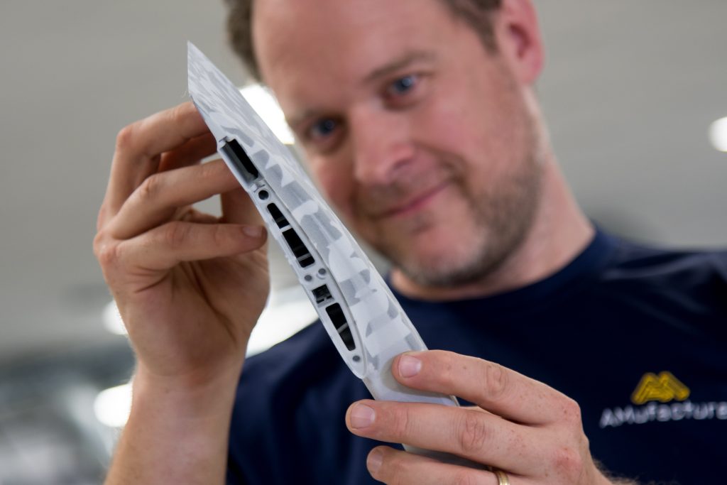 A person inspecting a 3D printed component.