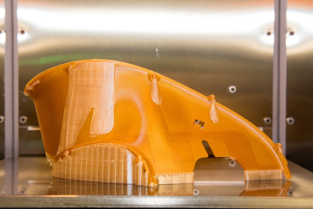A finished 3D printed component in a printer.